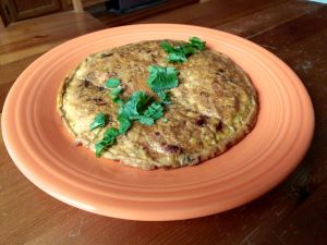An Indian omelette topped with coriander leaf.